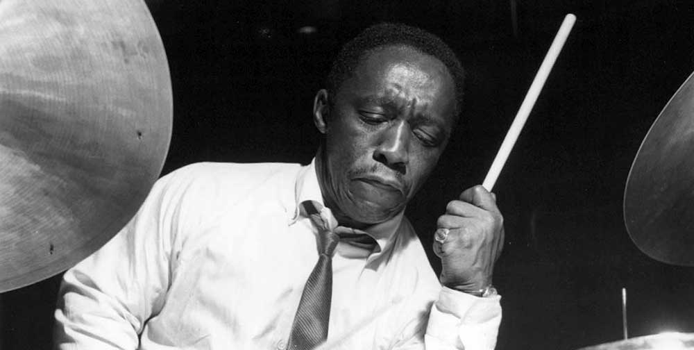 Photographie en noir et blanc d'Art Blakey jouant de la batterie.
