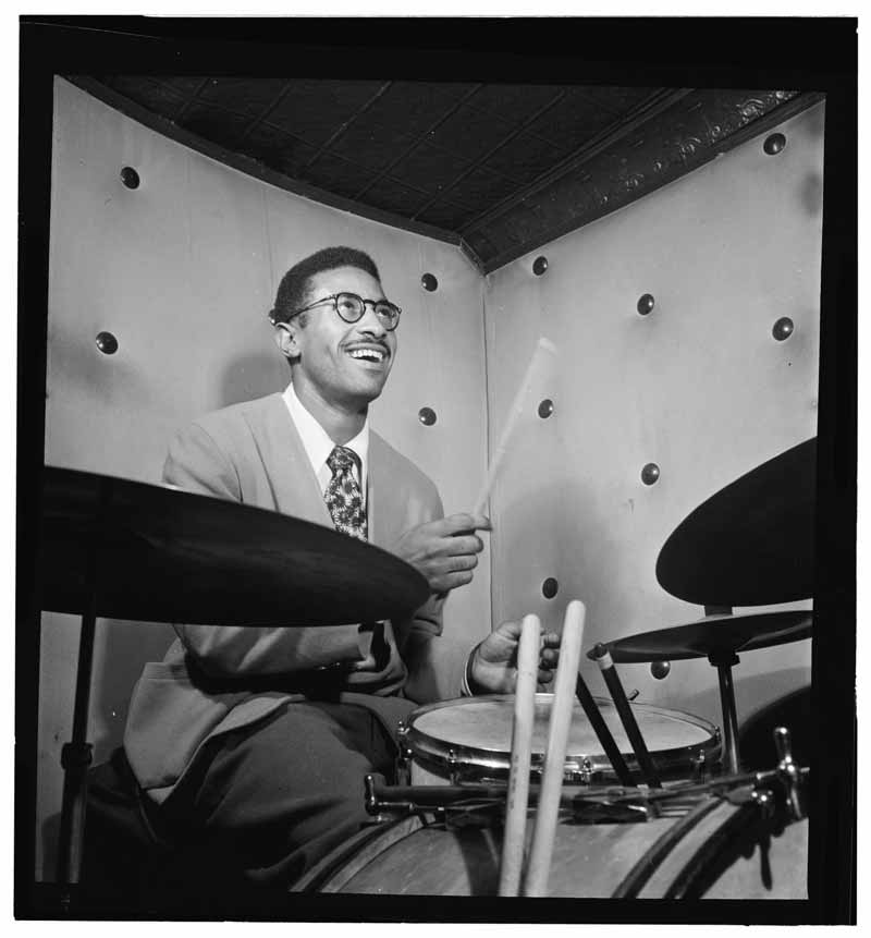 Photo en noir et blanc de Max Roach jouant de la batterie par William Gottlieb.