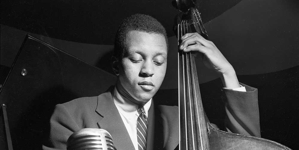 Portrait en noir et blanc par Francis Wolff du musicien de jazz Doug Watkins jouant de la basse.