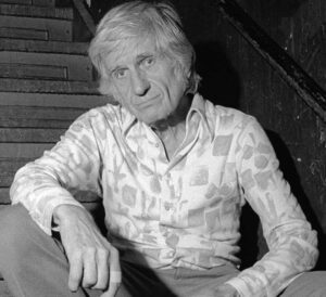 Photo noir et blanc de l'arrangeur Gil Evans, assis dans un escalier. Site de vente de vinyles Everything Jazz.
