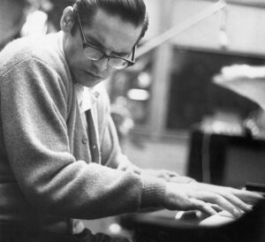 Bill Evans jouant du piano en studio, photo noir et blanc. Photo sur le site de vente de vinyles jazz Everything Jazz.